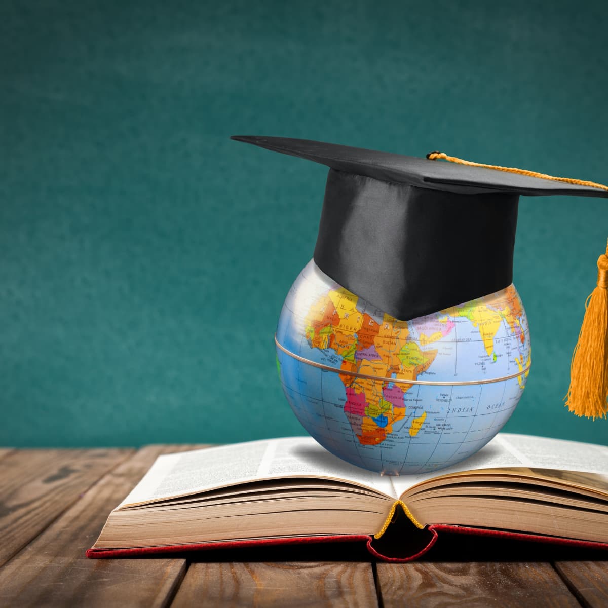 Globe with graduation cap on open book — CRF Academy, education for Africa