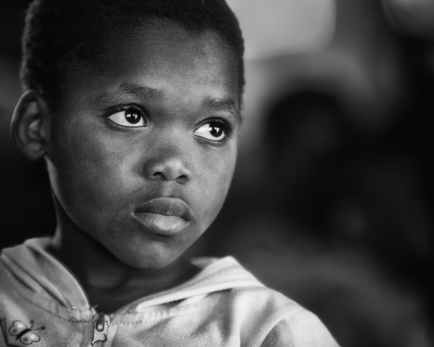 B&W close-up portrait of a child — quiet strength, seen and known