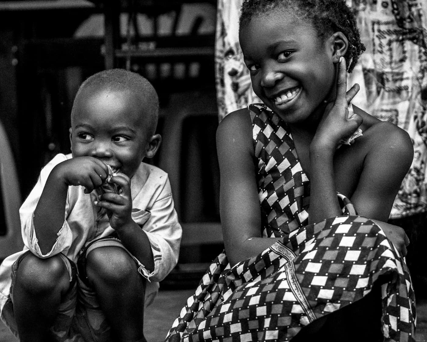 B&W toddler and older girl smiling together